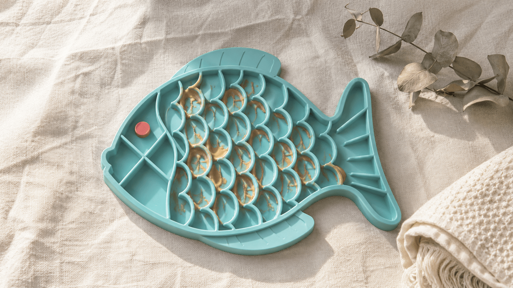 Close-up of the teal fish-shaped Soothe Mat
